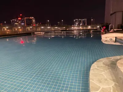 a swimming pool at night with a city in the background at Female Hostel wakakapacker in Kuala Lumpur