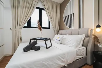 a bedroom with a white bed with a table on it at Trendy 3BR MVertica Near MRT by RumaBnB in Kuala Lumpur