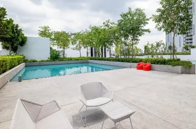 a swimming pool with two chairs and a table at 10pax Comfy Homestay 5 Min-MITEC in Kuala Lumpur