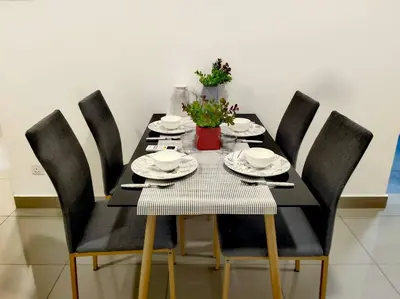 a dining room table with black chairs and a black table with plates and dishes at lavile residence in Kuala Lumpur