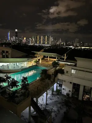 a swimming pool at night with a city in the background at Cozy 2BR Apt AxisAtrium Mall wPool Pandan Indah Ampang Kuala Lumpur in Ampang