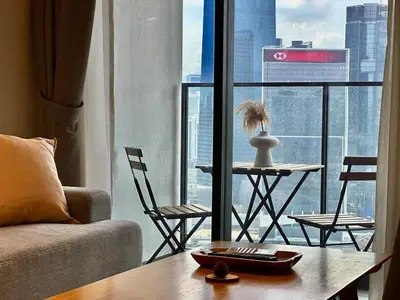 a living room with a couch and a table in front of a window at 7Pax Muji Continew KL Centre View 10mins to TRX KLCC IKEA in Kuala Lumpur
