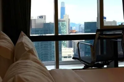 a bedroom with a bed and a chair in front of a window at The Platinum kuala lumpur By MAJU in Kuala Lumpur