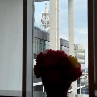 a vase filled with flowers in front of a window at The Platinum kuala lumpur By MAJU in Kuala Lumpur