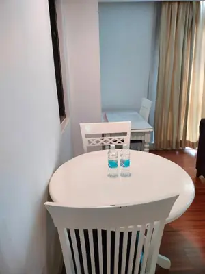 a white table and chairs with two glasses on it at Quitecove Service Suite at Times Square KL in Kuala Lumpur
