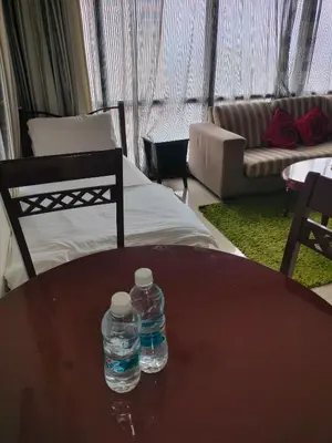 two water bottles sitting on a table in a living room at Quitecove Service Suite at Times Square KL in Kuala Lumpur