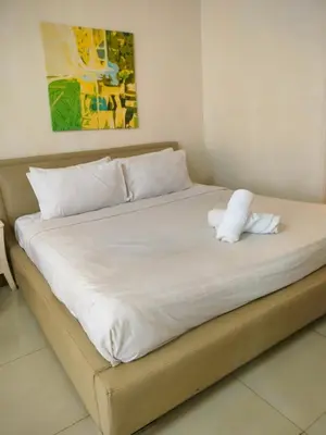 a large bed with white sheets and pillows at Quitecove Service Suite at Times Square KL in Kuala Lumpur