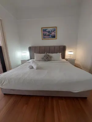 a bedroom with a large white bed with two lamps at Rainfall Suite And Service at Time Squre KL in Kuala Lumpur