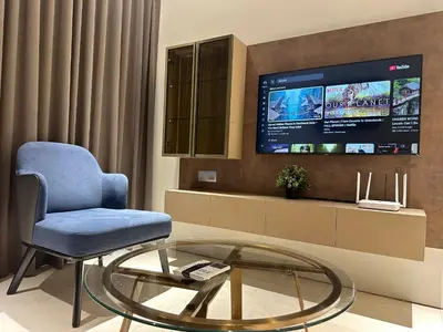 a living room with a chair and a glass table at Sky Suites KLCC by The Sense in Kuala Lumpur