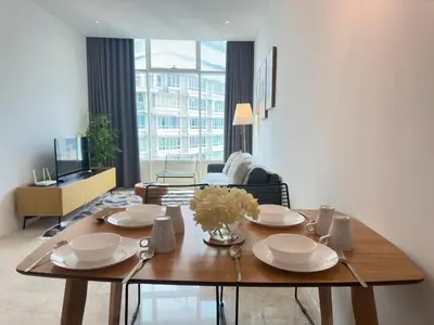 a dining room table with plates and flowers on it at Sky Suites KLCC by The Sense in Kuala Lumpur