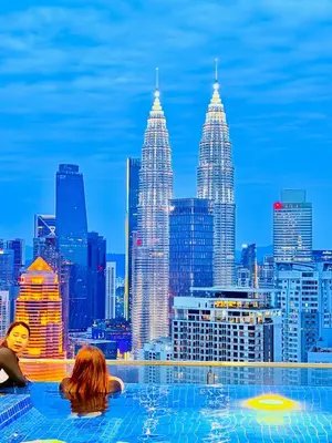 two women in a infinity pool with a view of the city at Colony Greenfield Suites Klcc in Kuala Lumpur