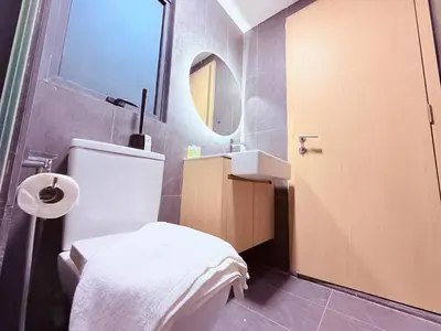 a bathroom with a toilet and a sink and a mirror at Colony Greenfield Suites Klcc in Kuala Lumpur