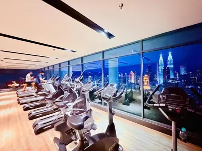 a gym with a row of cardio machines at Colony Greenfield Suites Klcc in Kuala Lumpur