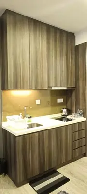 a kitchen with wooden cabinets and a sink at CozyNest Suites Bukit Bintang in Kuala Lumpur