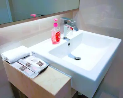 a bathroom sink with a bottle of soap on it at CozyNest Suites Bukit Bintang in Kuala Lumpur