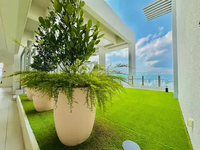 a balcony with two large pots with plants on it at Agile Suites TRX KlCC in Kuala Lumpur