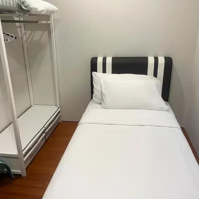 a bed with a black and white headboard in a room at Dawn Legacy Suite in Kuala Lumpur