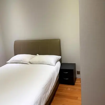 a bedroom with a large bed and a night stand at Dawn Legacy Suite in Kuala Lumpur