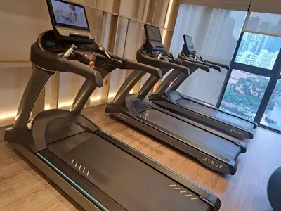 a row of treadmill machines in a room with windows at Agile Malaysia Apartment KL in Kuala Lumpur