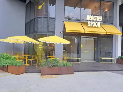 a restaurant with yellow tables and chairs and umbrellas at Agile Malaysia Apartment KL in Kuala Lumpur