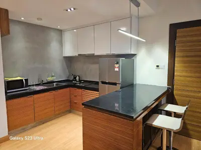 a kitchen with a black counter top and wooden cabinets at Executive Suite Dua Sentral in Kuala Lumpur