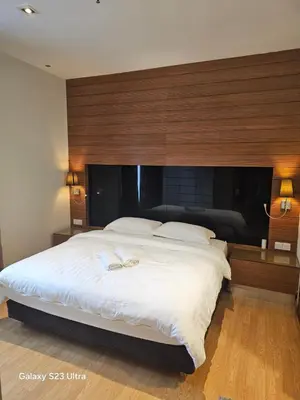 a bedroom with a large bed with a wooden headboard at Executive Suite Dua Sentral in Kuala Lumpur