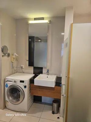 a bathroom with a washing machine and a sink at Executive Suite Dua Sentral in Kuala Lumpur