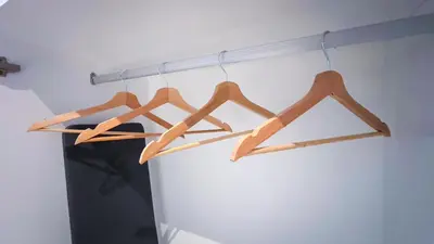 a bunch of wooden hangers hanging from a pole at Scarletz Suite KLCC by Light House 1 in Kuala Lumpur