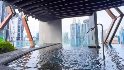 a swimming pool with a fountain in a building at Scarletz Suite KLCC by Light House 1 in Kuala Lumpur