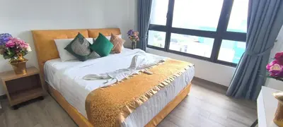 a bedroom with a bed with green pillows and a window at Agile Service Residence by TRX KLCC in Kuala Lumpur