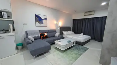 a living room with a couch and a table at Summer Suites Klcc by Sikka in Kuala Lumpur