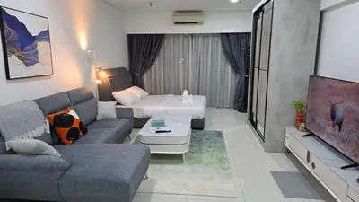 a living room with a couch and a flat screen tv at Summer Suites Klcc by Sikka in Kuala Lumpur