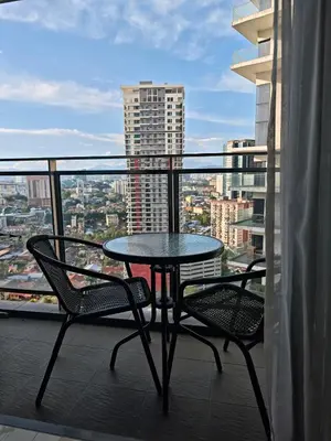 a table and chairs on a balcony with a view at Summer Suites Klcc by Sikka in Kuala Lumpur