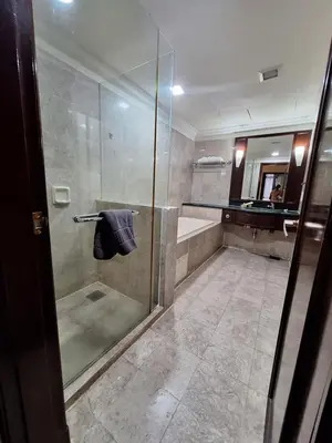 a bathroom with a glass shower with a sink at KL Times Square Hotel Service Suite in Kuala Lumpur