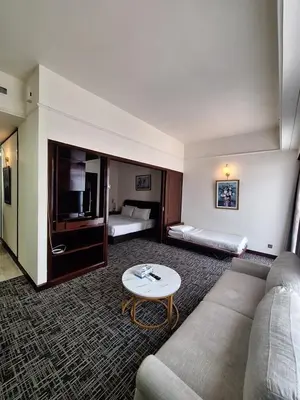 a hotel room with a couch and a table at KL Times Square Hotel Service Suite in Kuala Lumpur