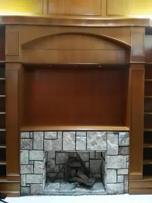 a fireplace with a brown mantle and a stone at Cardogan Hotel in Kuala Lumpur