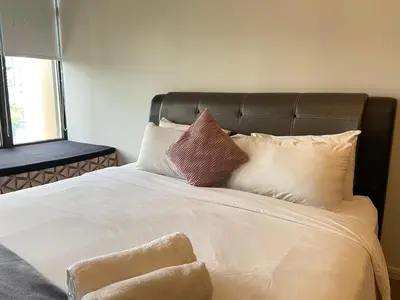 a bed with four pillows on top of it at Staybliss At Ceylonz Suites KLCC in Kuala Lumpur