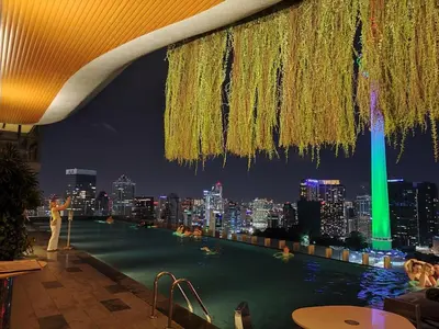 a rooftop pool with a city skyline at night at Staybliss At Ceylonz Suites KLCC in Kuala Lumpur