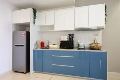 a kitchen with blue cabinets and a refrigerator at Luxurious TRX Corner Dual Balconies 2 Bedrooms in Kuala Lumpur