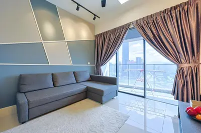 a living room with a couch and a large window at Luxurious TRX Corner Dual Balconies 2 Bedrooms in Kuala Lumpur