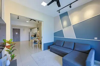 a living room with a couch and a blue wall at Luxurious TRX Corner Dual Balconies 2 Bedrooms in Kuala Lumpur