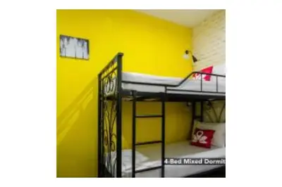 a room with two bunk beds and a yellow wall at The Explorers Guesthouse and Hostel in Kuala Lumpur