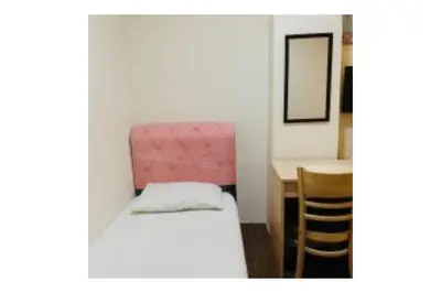 a small room with a bed and a desk at The Explorers Guesthouse and Hostel in Kuala Lumpur