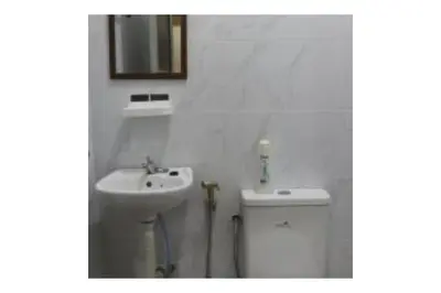 a white bathroom with a sink and a toilet at The Explorers Guesthouse and Hostel in Kuala Lumpur