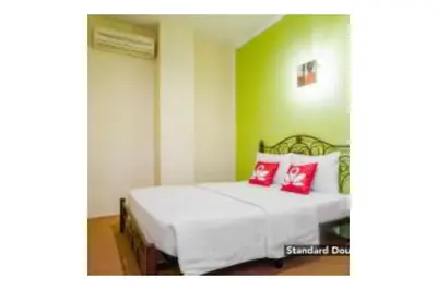 a bedroom with a bed with two red pillows at The Explorers Guesthouse and Hostel in Kuala Lumpur