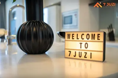 a welcome sign sitting next to a vase on a table at SkyPool KLCC 2BR Platinum Suite D33F with Netflix in Kuala Lumpur
