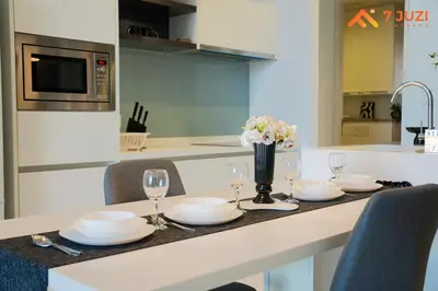 a kitchen with a table with plates and wine glasses at SkyPool KLCC 2BR Platinum Suite D33F with Netflix in Kuala Lumpur