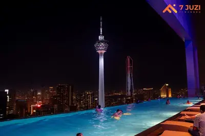a swimming pool with people in the city at night at Sky Pool KLCC 2BR Platinum Suite C33 with Netflix in Kuala Lumpur
