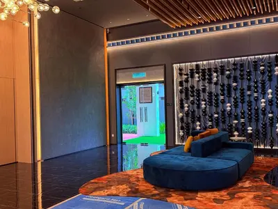 a lobby with a blue couch and a wall of wine bottles at Majestic Luxury Suites KLCC By Home stay in Kuala Lumpur