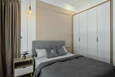 a bedroom with a large bed with a gray bedspread at Jln Razak Mansion, in Kuala Lumpur